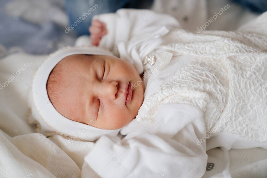 El bebe recien nacido duerme con ropa blanca. vestimenta para el alta del hospital. Foto de stock sayfutdinov 483102576