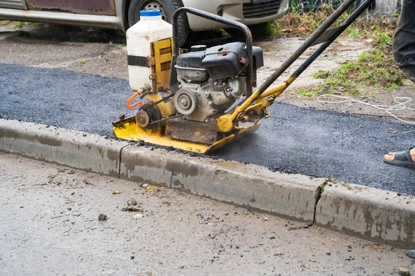 Vibrationsplatte, ein Bauwerkzeug, das Straßenbauarbeiten ausführt — Stockfoto