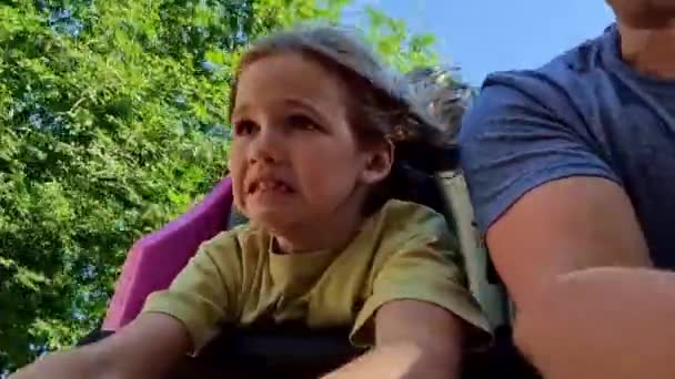 Vater und Tochter fahren eine extreme Attraktion. Adrenalin und Spaß im Freizeitpark — Stockvideo