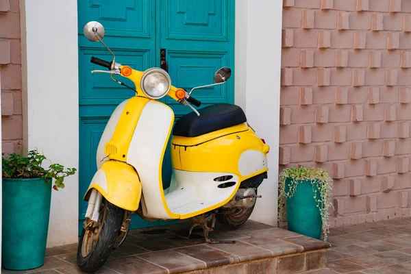 yellow motorcycle at the turquoise wooden door