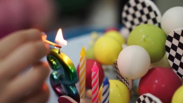 Свечи зажигаются на праздничном торте со спичками. традиция празднования дней рождения — стоковое видео