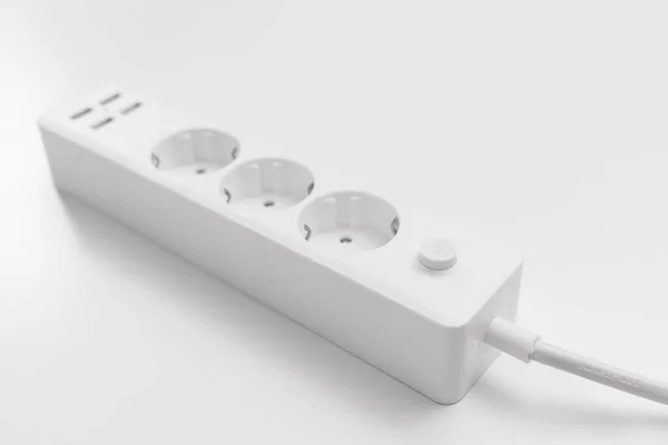 Un versátil cable de extensión blanco moderno con enchufes y puertos USB —  Fotos de Stock