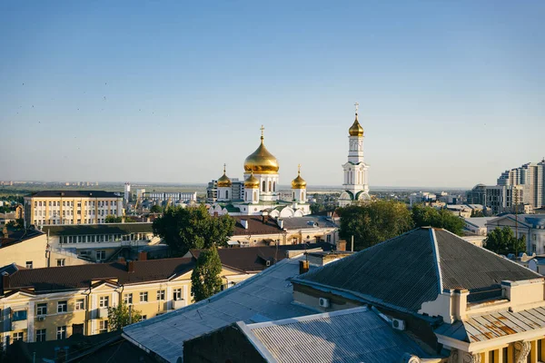 Uitzicht vanaf het dak naar de avondstad en de orthodoxe kerk. — Stockfoto