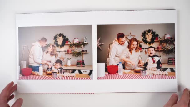 Bovenaanzicht. een fotoboek van de Oud en Nieuw familie fotoshoot wordt doorgebladerd — Stockvideo