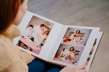 Kadın, mutfaktaki bir aile fotoğraf çekiminin fotobook sayfalarını karıştırıyor.