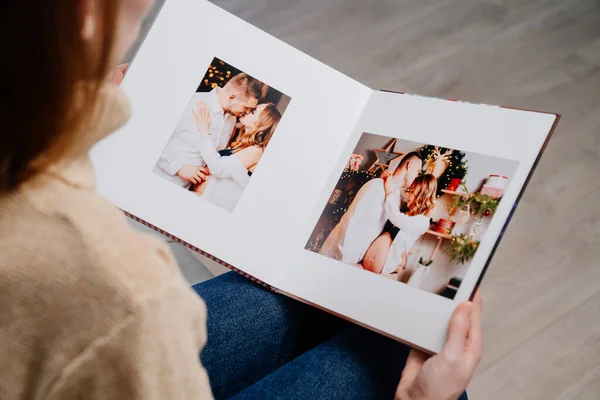 Женщина смотрит фотокнигу с фотосессии супружеской пары во время беременности. — стоковое фото