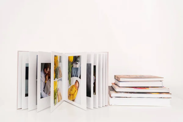 Sobre mesa blanca libro de fotos abierto de sesión de fotos de la familia con el recién nacido. —  Fotos de Stock