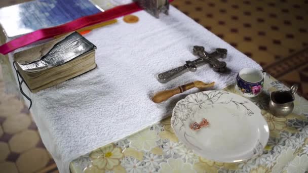 Artículos para el bautismo de un niño en la Iglesia Ortodoxa sobre la mesa. — Vídeos de Stock