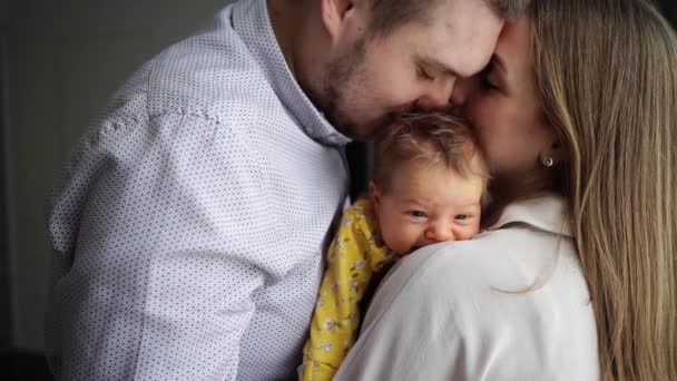 Sevgi dolu ebeveynler bir bebek tutup öpüşürler. Babalığın ve anneliğin mutluluğu.. — Stok video
