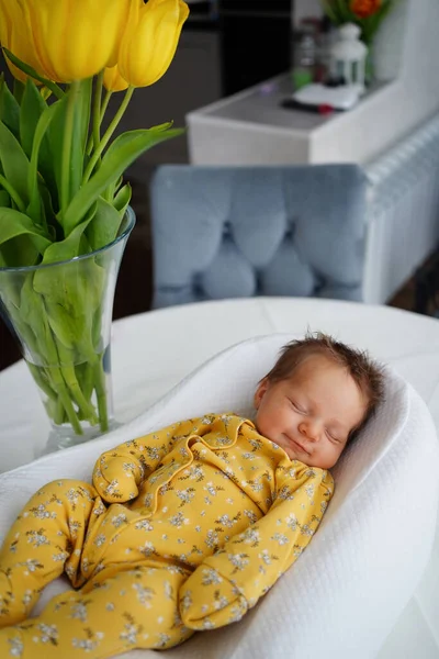 Νεογέννητο μωρό με κίτρινη φόρμα βρίσκεται σε ένα δοχείο για την ασφάλεια του παιδιού — Φωτογραφία Αρχείου