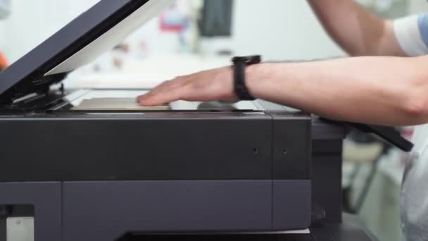 Un uomo fa copie di documenti su una fotocopiatrice. attrezzature per ufficio e casa — Video Stock