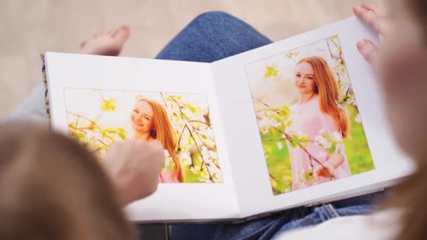 Top view.mother e figlia guardare photobook servizio fotografico di famiglia in giardino primaverile — Video Stock