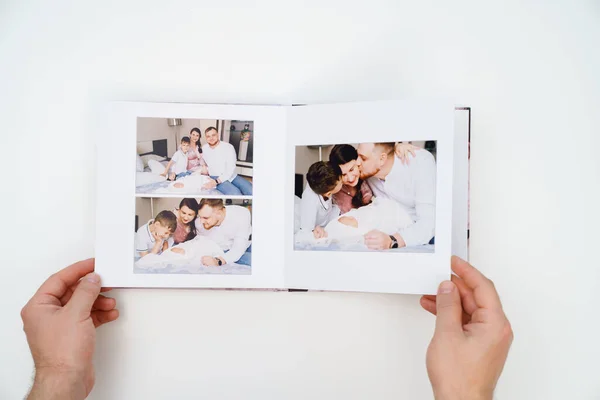 På vit bakgrund, händer bläddra igenom fotobok från hemmet familj fotografering — Stockfoto