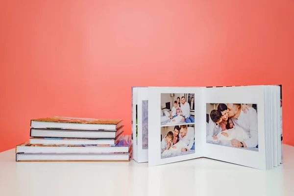 Pembe arka plan fotobooks. Yeni doğmuş bebeklerle aile fotoğraf çekiminden açık albüm