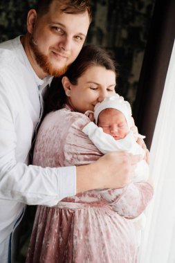 Kollarında bebek olan mutlu bir çift. Hastaneden taburcu oldum. Evdeki ilk günüm.