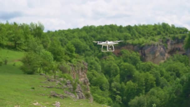 Een witte drone vliegt over de bergen en schiet een video. — Stockvideo