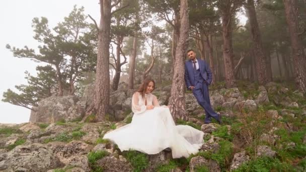 Sposa e sposo in una misteriosa foresta di montagna nebbiosa. servizio fotografico dietro le quinte — Video Stock