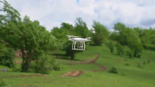 Un dron blanco vuela sobre las montañas y dispara un video. — Vídeos de Stock