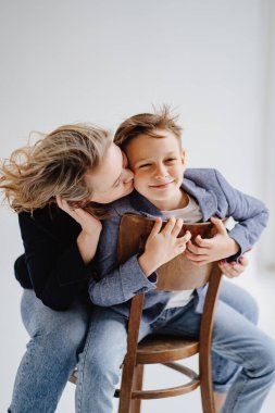 Mavi elbiseli bir anne eğleniyor ve fotoğraf çekimi için poz veriyor.