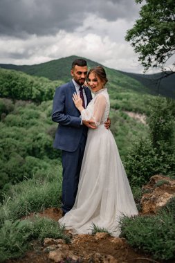 Dağlarda bir düğün töreninde yeni evlilere nazikçe sarılmak.