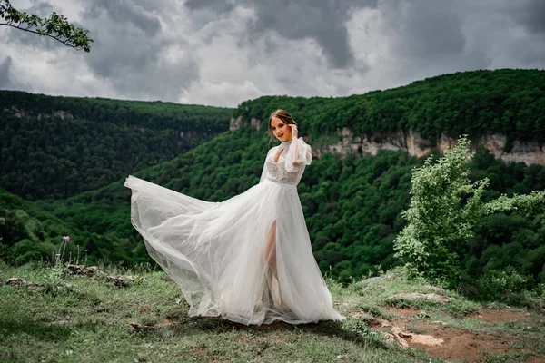 wedding photo shoot in the mountains. the bride in flutters skirt on the meadow.