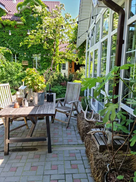 Maison de campagne avec fenêtres panoramiques et une table pour le déjeuner dans le jardin d'été. — Photo
