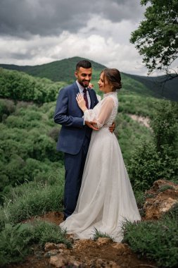 Dağlarda bir düğün töreninde yeni evlilere nazikçe sarılmak.