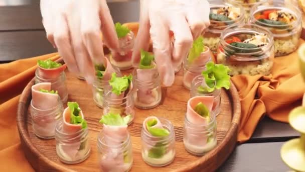 Trabajo de catering. tazas con bocadillo de carne se colocan en una tabla de cortar de madera redonda — Vídeos de Stock