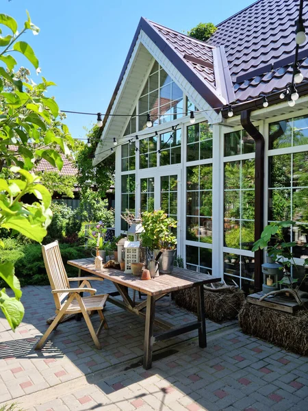 Заміський будинок з панорамними вікнами і столом для обіду в літньому саду . — стокове фото