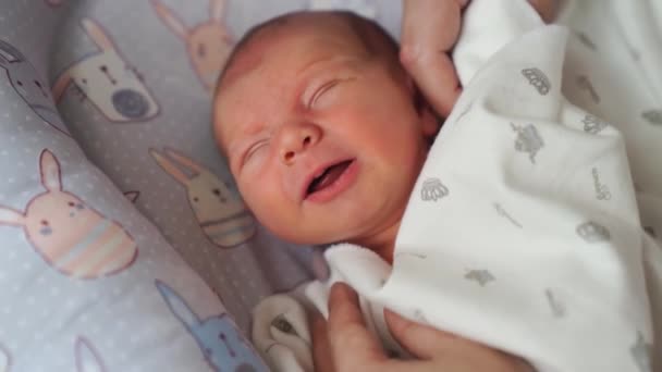 Máminy ruce narovnají přikrývku na spaní v kolébce novorozence. — Stock video