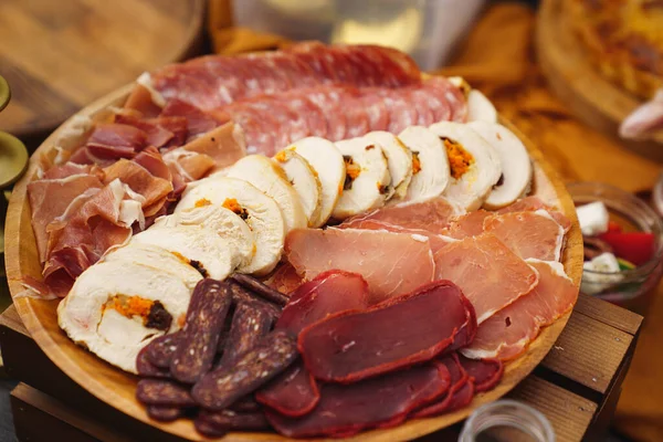다양 한 고기자르기. 소시지, 미트로프, 둥근 나무 접시 위의 햄. — 스톡 사진