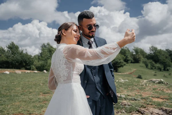 A noiva e o noivo tiram uma selfie juntos. transmissão de casamento online. — Fotografia de Stock