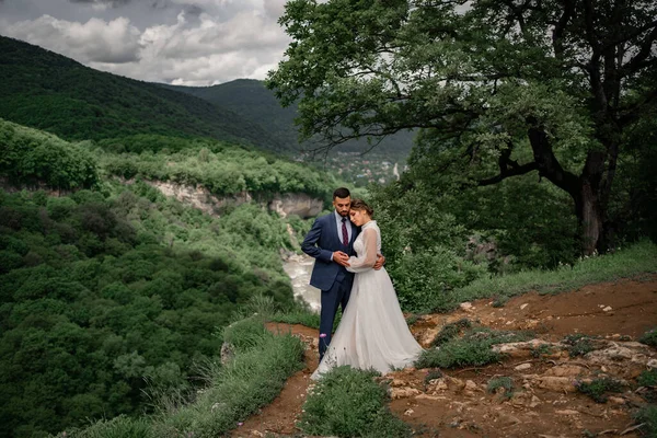 Mariage en montagne. doux jeunes mariés sur fond de forêt de montagne. — Photo