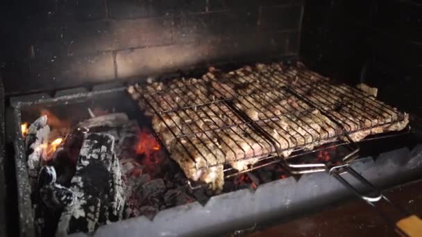Meat is cooked on firewood burning in the barbecue oven. grill in the house. — Stock Video