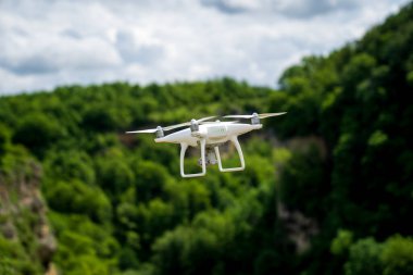 Beyaz bir dron dağların üzerinden uçar ve bir video çeker.. 