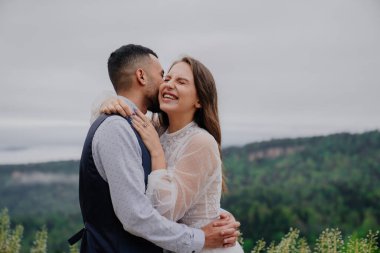 Çekici erkek ve kadın doğada sarılıp gülüyorlar. romantizm ilişkisi