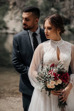 Bir dağ gölünün kıyısındaki yeni evlileri seviyorlar..