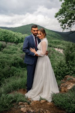 Dağlarda bir düğün töreninde yeni evlilere nazikçe sarılmak.