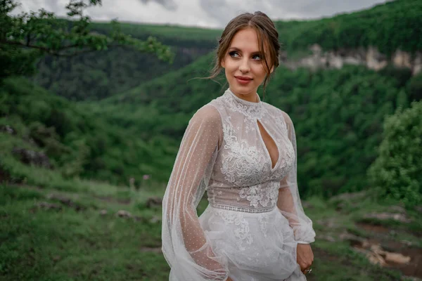 A noiva em um vestido branco contra o pano de fundo de uma paisagem montesa — Fotografia de Stock