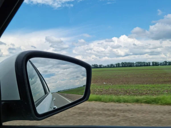 Miroir latéral. prise de vue depuis le siège passager. voyager le long de la route le long des champs. — Photo