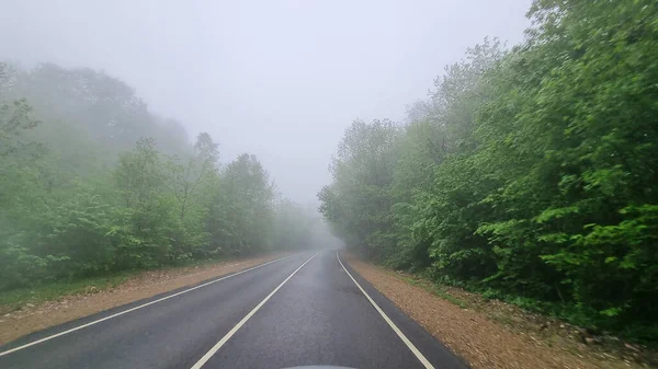 Через вітрове скло автомобільної дороги в тумані . — стокове фото