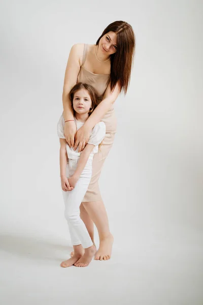Mama i córka pozują w białym studiu fotograficznym. — Zdjęcie stockowe