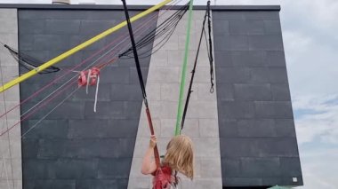 Küçük bir kız bungee trambolinde zıplıyor. parkta çocuklar için eğlence.