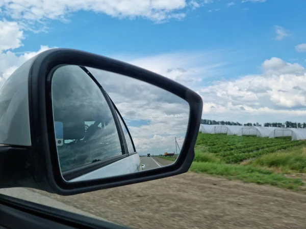 Miroir latéral. prise de vue depuis le siège passager. voyager le long de la route le long des champs. — Photo