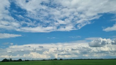 Mavi gökyüzü ve bulutlar ile yeşil alan. 