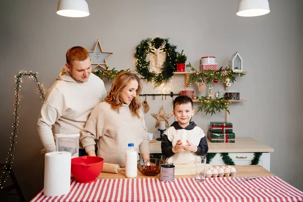 Família feliz e bonita em conjunto prepara pratos tradicionais para o ano novo — Fotografia de Stock