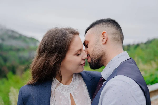 Braut und Bräutigam küssen sich zärtlich in der Natur. Romantik in der Beziehung — Stockfoto