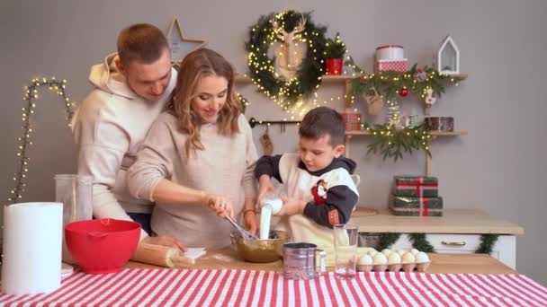 Küçük çocuk kendine süt döker. Aile birlikte yeni yıl için yemek hazırlar. — Stok video