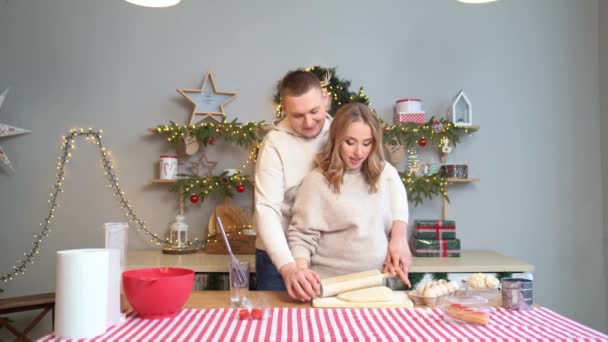 孕妇与丈夫在新年厨房里用滚针把面团铺开 — 图库视频影像
