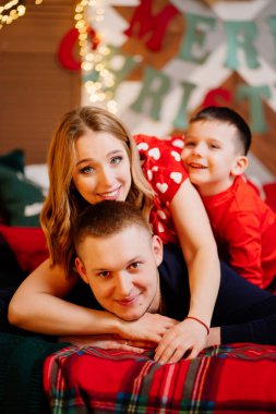 Yeni yıl yatağında pijamalı mutlu bir aile.. 